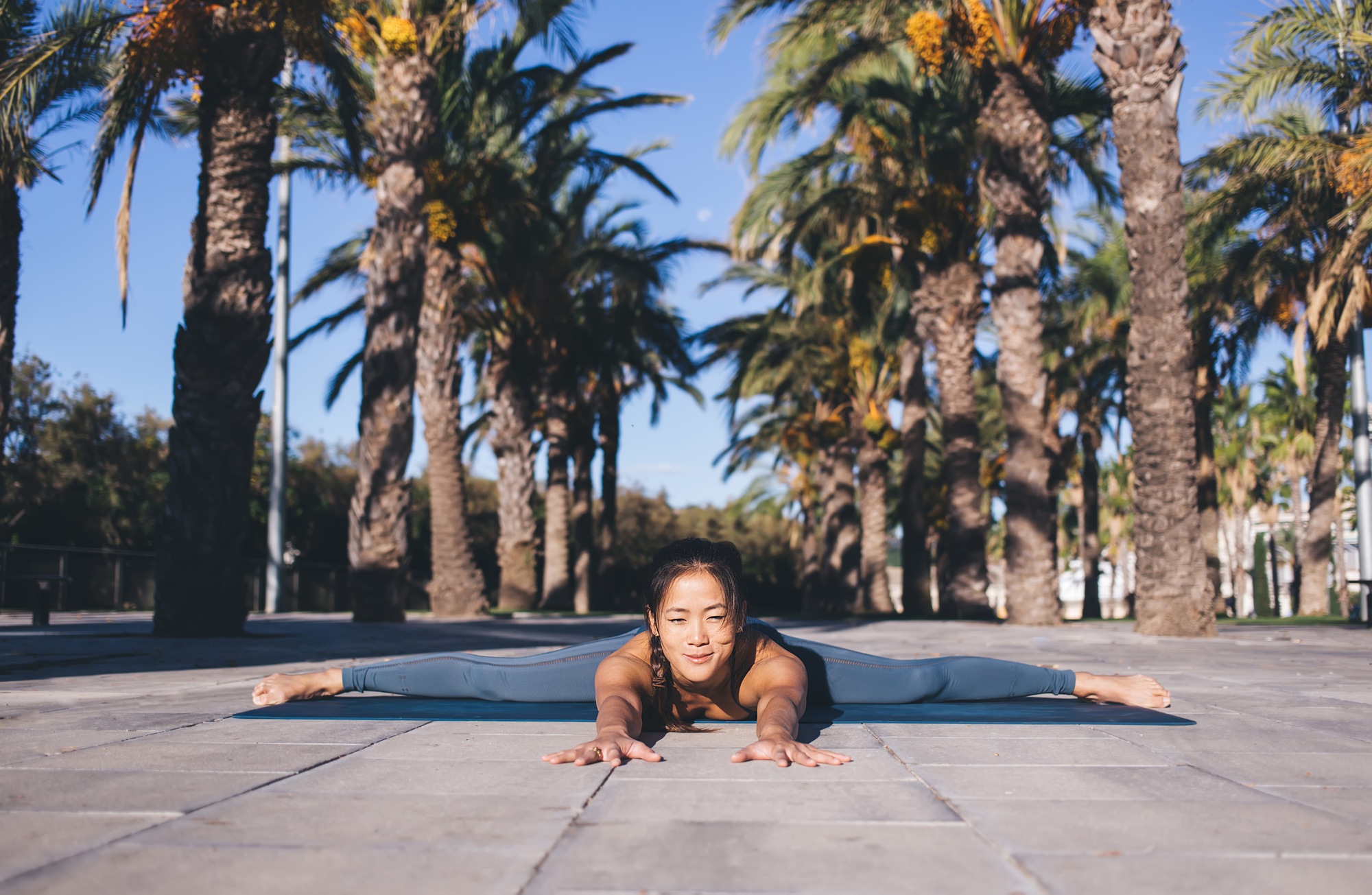 Asian fit trainer practice twine method during yoga therapy and morning warm up,