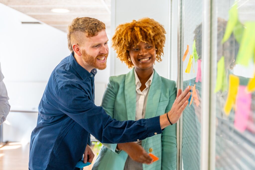 Happy man using post-it during a brainstorming