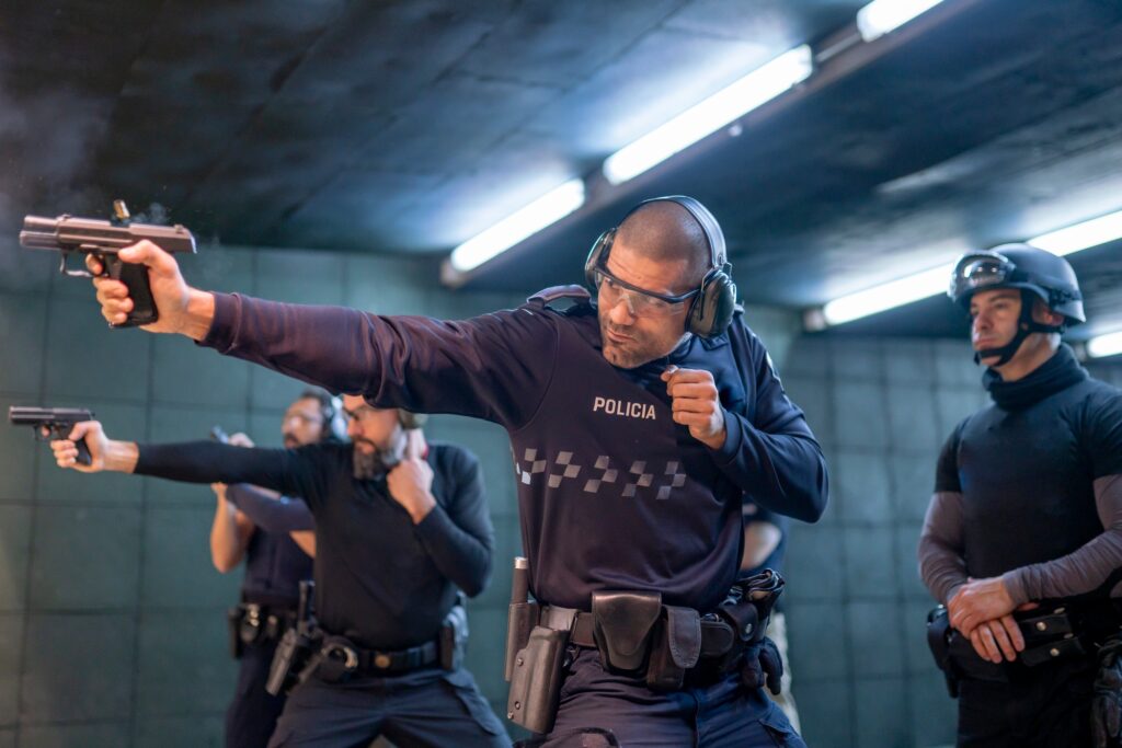 Police training in shooting gallery with short weapon.