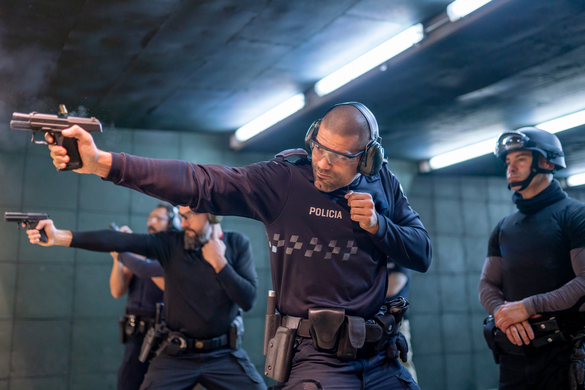 Police training in shooting gallery with short weapon.